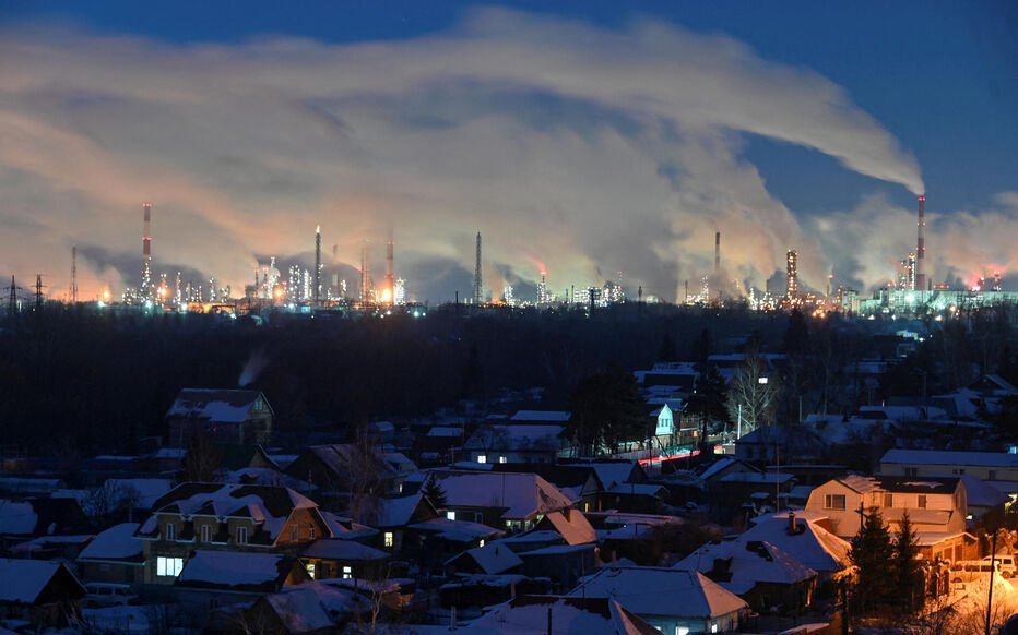 FILE PHOTO: Flue gas and steam rise out of chimneys of an oil refinery in Omsk